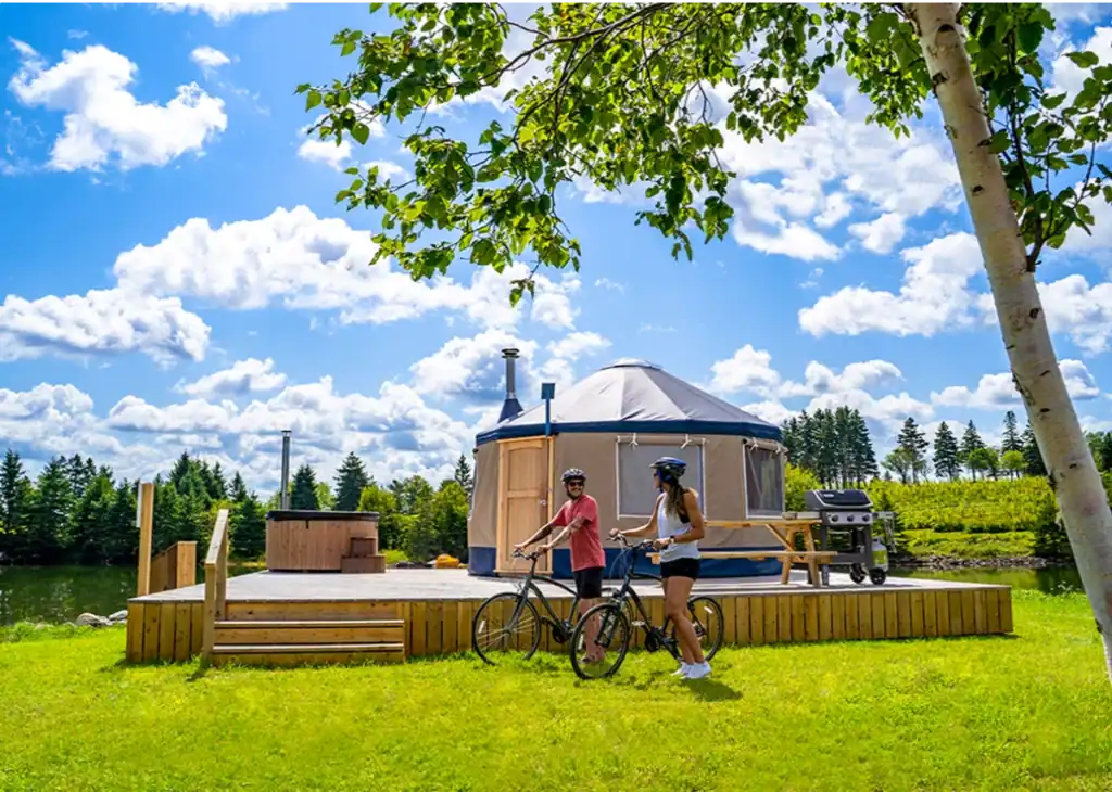 Yurta with outdoor deck situated by a lake, perfect for outdoor living and relaxation.