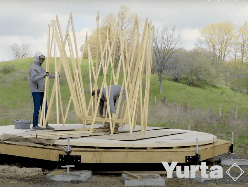 Yurta being assembled outdoors, showcasing the building process of this traditional structure.