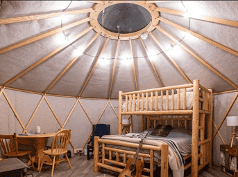Yurt interior featuring a cozy wooden bed and seating area, showcasing traditional design and warm l.