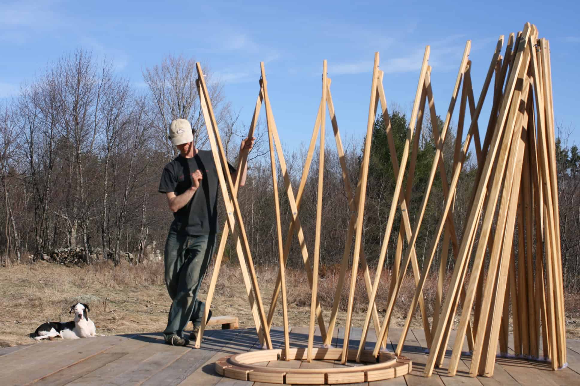 Yurta being assembled outdoors with wooden framework for a traditional portable dwelling.