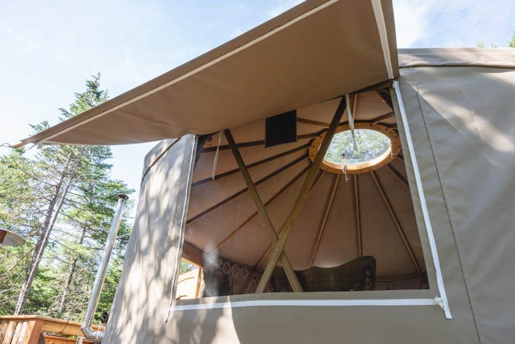 Looking into a yurt through a large window with awning